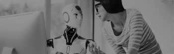 human woman and robot employee having a discussion in front of a desktop computer