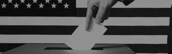 person casting their voting ballot into a box, standing in front of an american flag