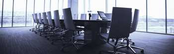 Photo of a boardroom with empty chairs in a high rise building to symbolize the high-level thinking involved in risk advisory consulting