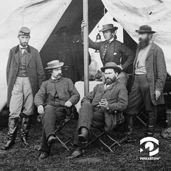 A photo of five men gathered around the entrance of a Civil War military tent