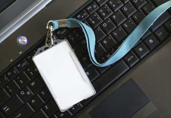 black and white image of a security badge laying on a computer keyboard